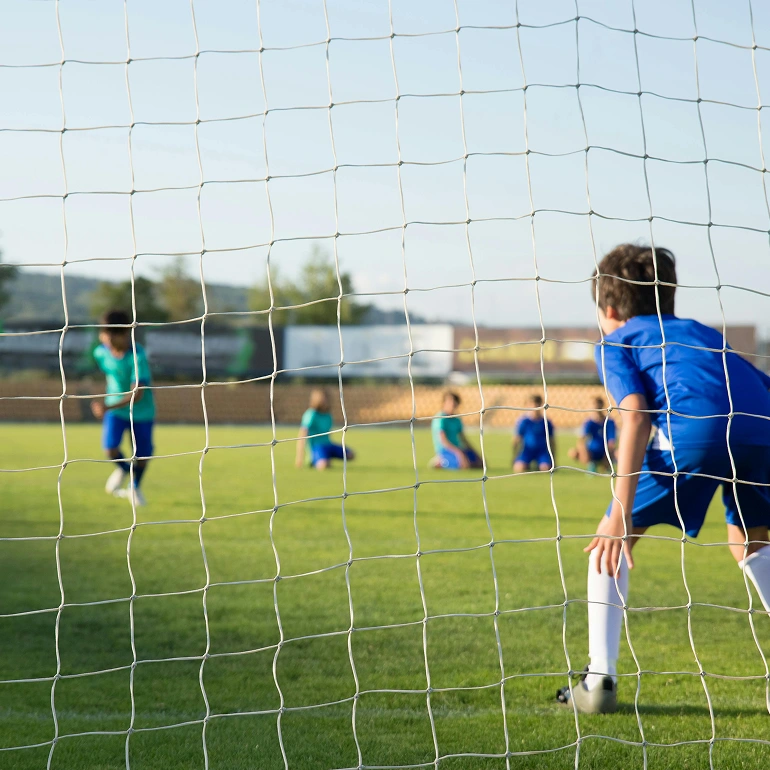 Youth soccer game seen through the goal net